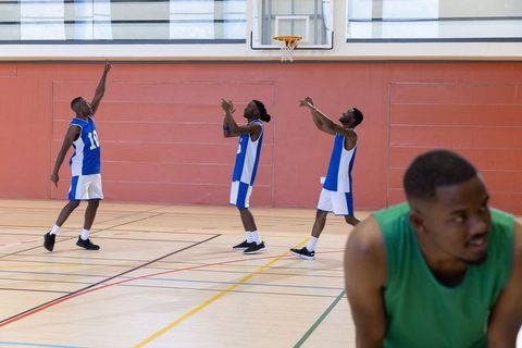 African american basketball players celebrating made shot on indoor court during practice