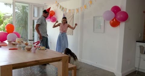 Family Celebrating Birthday with Joyful Decorations and Hats