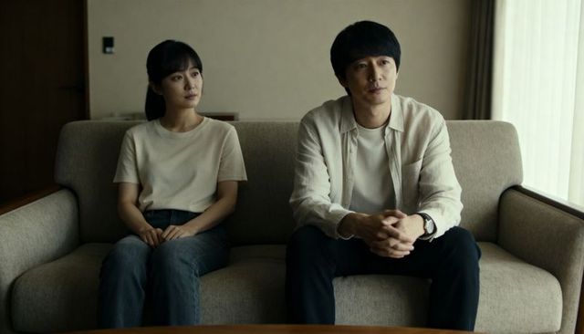 Couple sitting on sofa in minimalist living room, neutral tones and calm contemplation