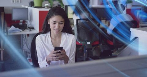 Office worker checking smartphone in open-plan workspace with blue motion streaks