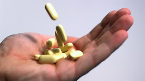 Slow Motion Capture of Tablets Dropping into Hand
