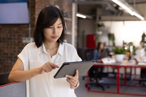Professional woman using tablet in modern industrial office