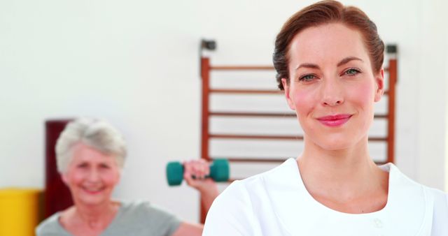 Smiling Female Physiotherapist with Senior Woman Exercising in Background - Download Free Stock Images Pikwizard.com