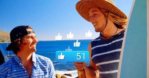 Sunlit male friends at beach holding surfboard and bottle with social likes overlay
