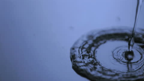 Liquid Transparently Flowing on Blue Surface in Slow Motion