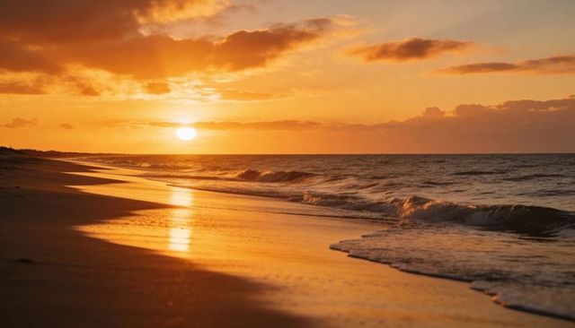 Golden sunset over tranquil ocean shoreline reflecting on wet sand with gentle surf