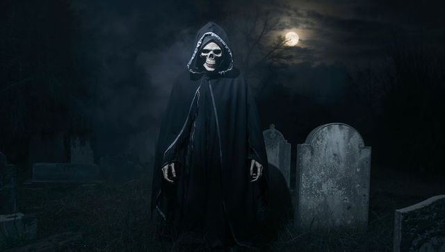 Hooded Reaper Stands Eerie Among Tombstones with Full Moon