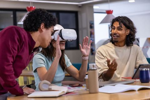 Team experimenting with vr headset while collaborating at modern coworkorking table