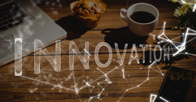 This visual depicts a modern office workspace featuring a laptop, coffee cup, and cupcake on a wooden desk, with the word 'INNOVATION' digitally superimposed. Ideal for use in presentations, websites, and marketing materials that emphasize creativity and technology in the workplace.