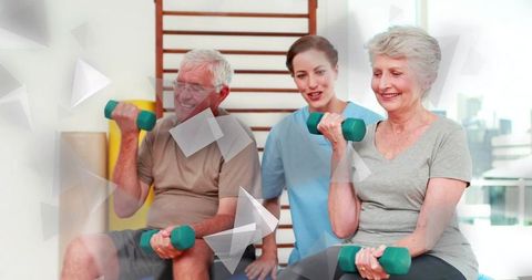 Senior couple lifting dumbbells during rehabilitation session guided by female physical therapist