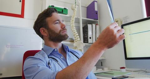 Caucasian Doctor Analyzing X-ray in Modern Office Setting - Download Free Stock Images Pikwizard.com
