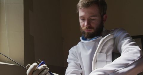 Focused Fencer Preparing for Duel in Training Center