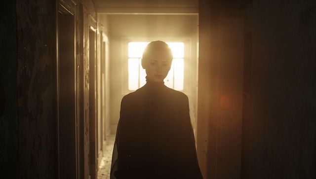 Backlit Silhouette Woman Standing in Abandoned Corridor with Window Flare and Moody Light