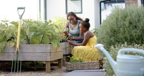 Mother and daughter gardening bonding in backyard