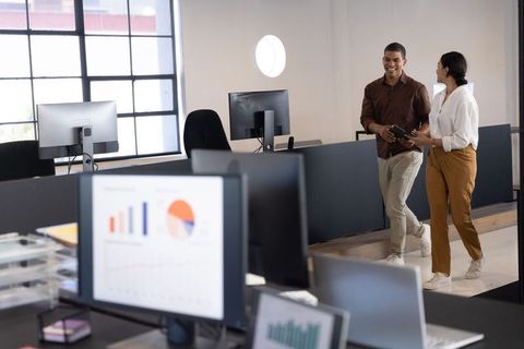 Diverse Colleagues Discussing Tech in Open Workspace