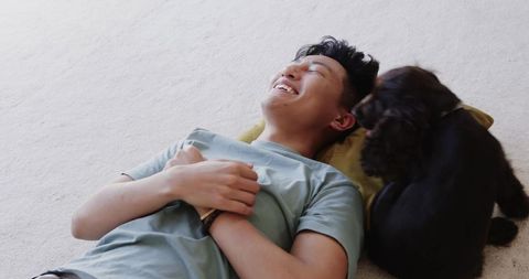 Relaxed man enjoying moment with affectionate puppy at home