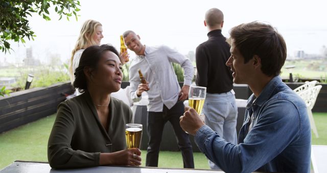 Friends gathering outdoors, socializing and enjoying drinks. Suitable for themes related to social events, friendship, leisure activities, and outdoor parties. Use for advertising gatherings, social events, or lifestyle content.