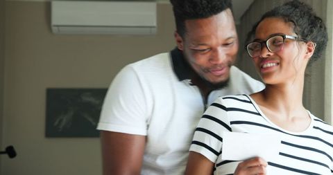 Expectant Couple Smiling While Viewing Sonogram at Home