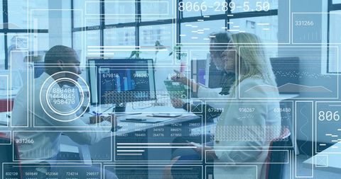 Business team analyzing data on dual monitors in modern office environment