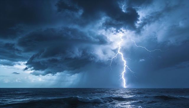 Branched lightning striking ocean horizon illuminating storm clouds and churning waves