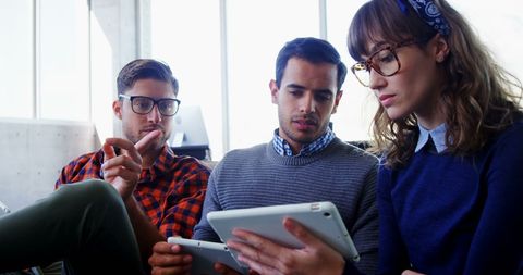 Young professionals collaborating in modern workplace with technology