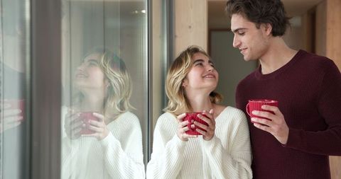 Romantic Couple Sharing Warm Moments with Coffee Near Window