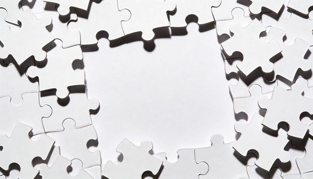 Forming white jigsaw pieces framing empty central space with stark shadows and negative space