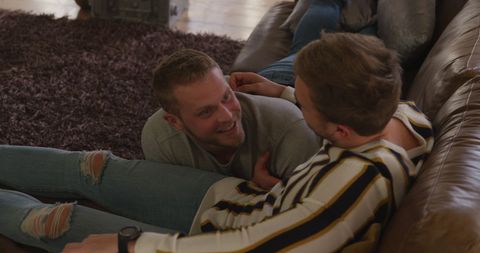 Joyful Gay Couple Relaxing and Communicating on Couch