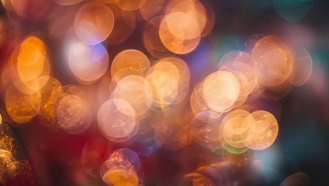 Glowing amber bokeh orbs abstract background, soft defocused warm lights and reflections