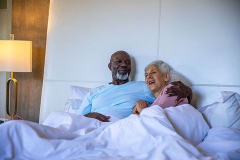 Smiling Elderly Couple Embracing in Cozy Bedroom