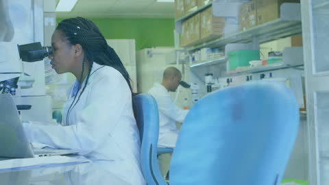 African American Female Scientist Using Microscope in Laboratory
