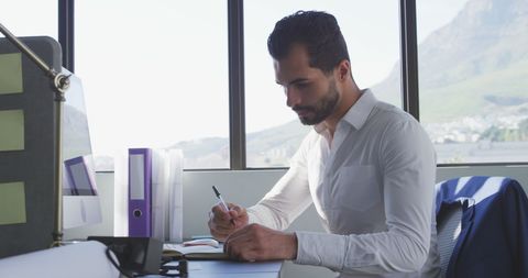 Focused Business Professional Writing in Modern Office - Download Free Stock Images Pikwizard.com