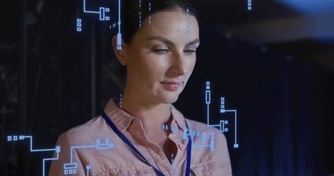 Female engineer interacting with holographic interface for data monitoring and analysis