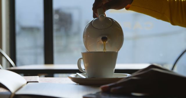 Pouring Tea from Teapot into Cup at Cozy Café - Download Free Stock Images Pikwizard.com