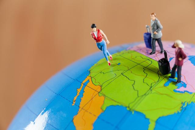 Conceptual image of miniature people travelling on globe