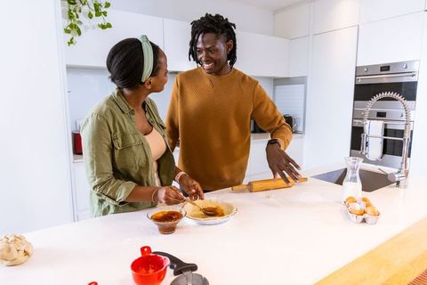 African american couple baking together in bright modern kitchen, preparing homemade pie