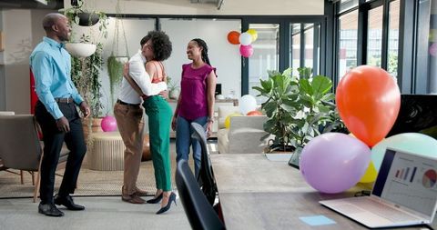 Diverse colleagues celebrating together in modern office