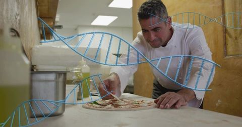 Mature chef preparing artisanal pizza with dna overlay representing food genetics