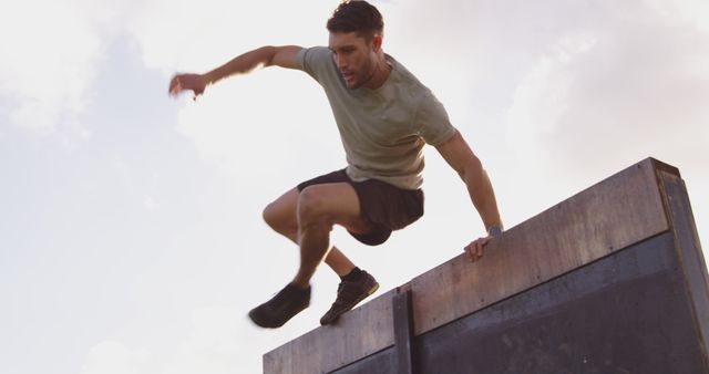 Young Man Practicing Parkour Jumping Over Wall - Download Free Stock Images Pikwizard.com