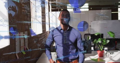 Smiling professional standing in modern open office with code overlays and sunlight