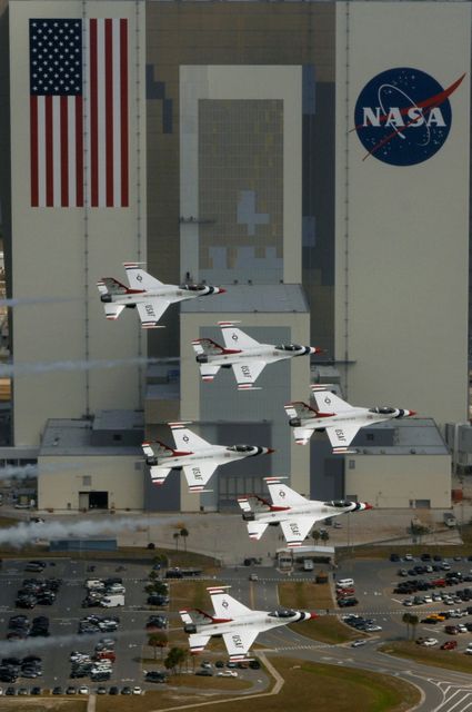 KENNEDY SPACE CENTER, FLA. --   U.S. Air Force Thunderbird F-16 jets fly in formation past the Vehicle Assembly Building in the Industrial Area of Kennedy Space Center.  The purpose of the flyover was to photograph the planes at KSC for promotional purposes. The Kennedy Space Center Visitor Complex will host the inaugural World Space Expo from Nov. 3 to 11, featuring an aerial salute by the Thunderbirds on its opening weekend. The Expo will create one of the largest displays of space artifacts, hardware and personalities ever assembled in one location with the objective to inspire, educate and engage the public by highlighting the achievements and benefits of space exploration. Photo credit: U.S. Air Force photograph by TSgt Justin D. Pyle