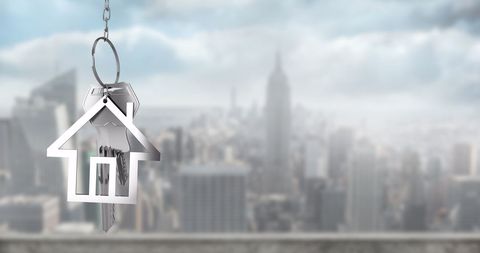 House-shaped Keychain Over Urban Skyline