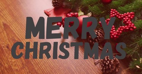 Merry christmas typography on rustic wood with evergreen garland and pine cones