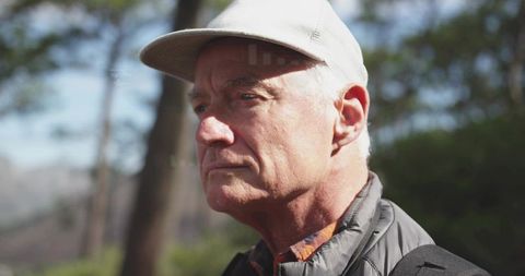 Senior Man Hiking in Forest with Cap and Backpack
