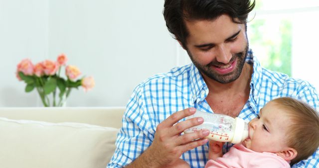 Loving father feeding baby with bottle at home - Download Free Stock Images Pikwizard.com