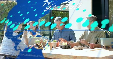 Four gardeners potting seedlings on sunny patio with blue data overlay for smart gardening