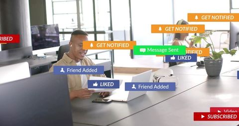Mid-adult professional working at shared desk receiving social media notifications and alerts