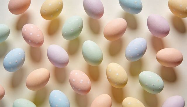 Floating pastel polka-dot easter eggs forming diagonal pattern flatlay on cream backdrop