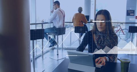 Businesswoman Analyzing Data Graphs on Digital Tablet in Modern Office