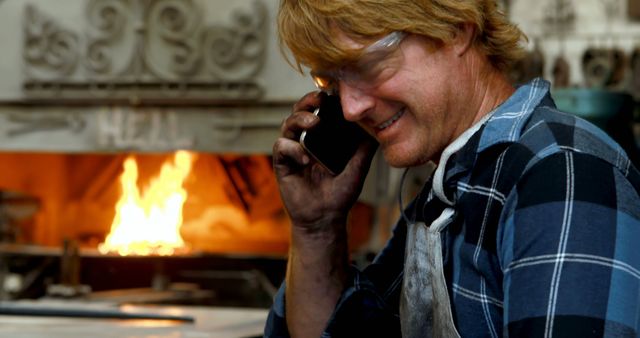 Portrait of Smiling Blacksmith Talking on Phone in Workshop - Download Free Stock Images Pikwizard.com